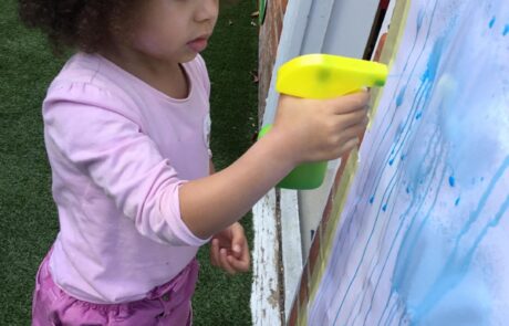 Nursery child enjoying water based art activity