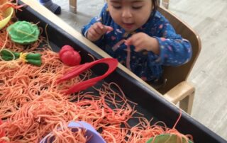 Nursery child exploring spaghetti and noodles